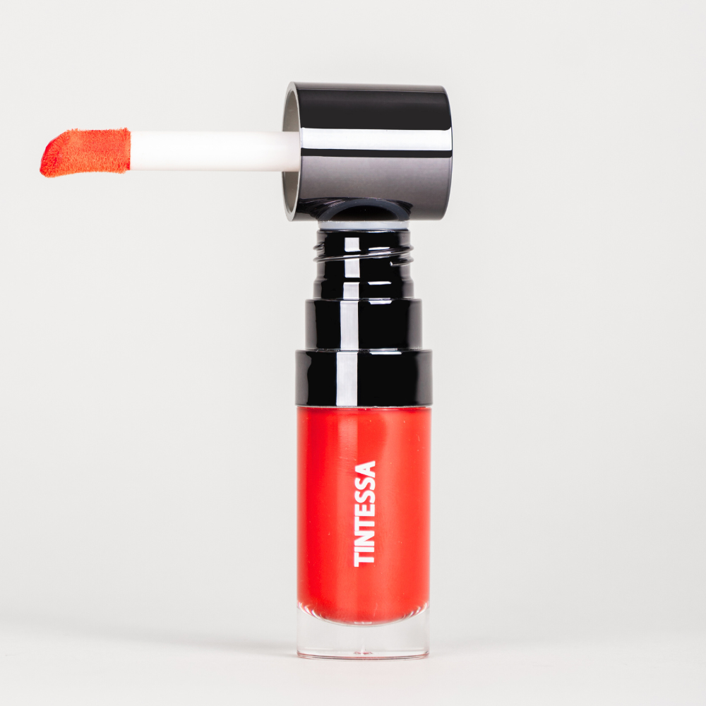 Cheek, lips and lids multi-use tint in red colour with applicator on a white background