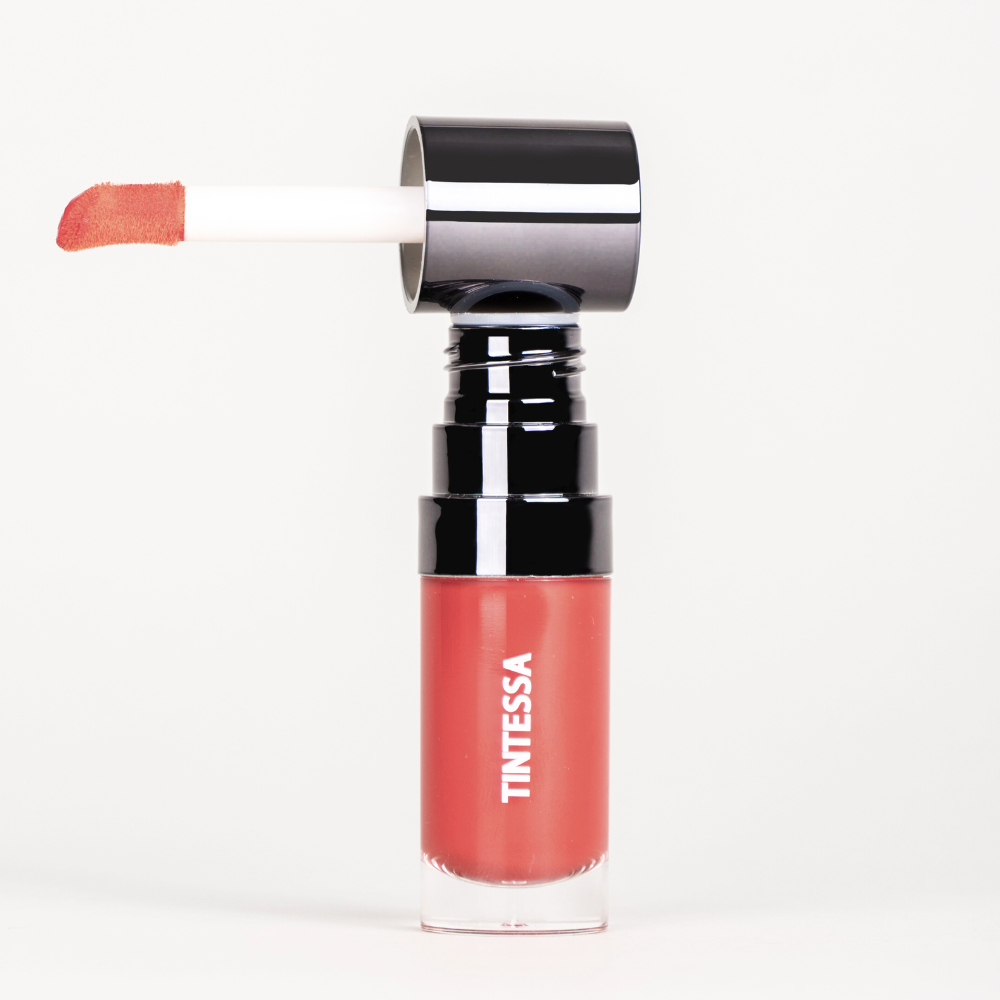 Cheek, lips and lids multi-use tint in red colour with applicator on a white background