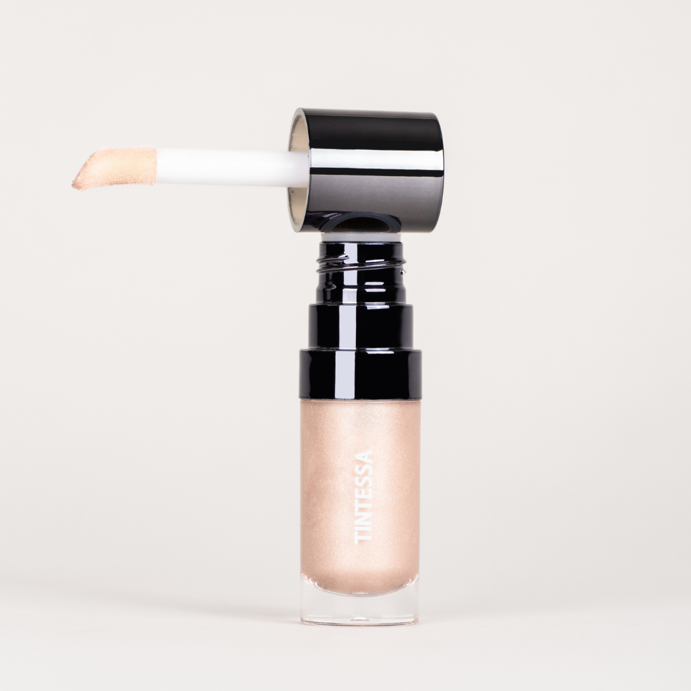 Cheek, lips and lids multi-use tint in champagne highlighter with applicator on a white background